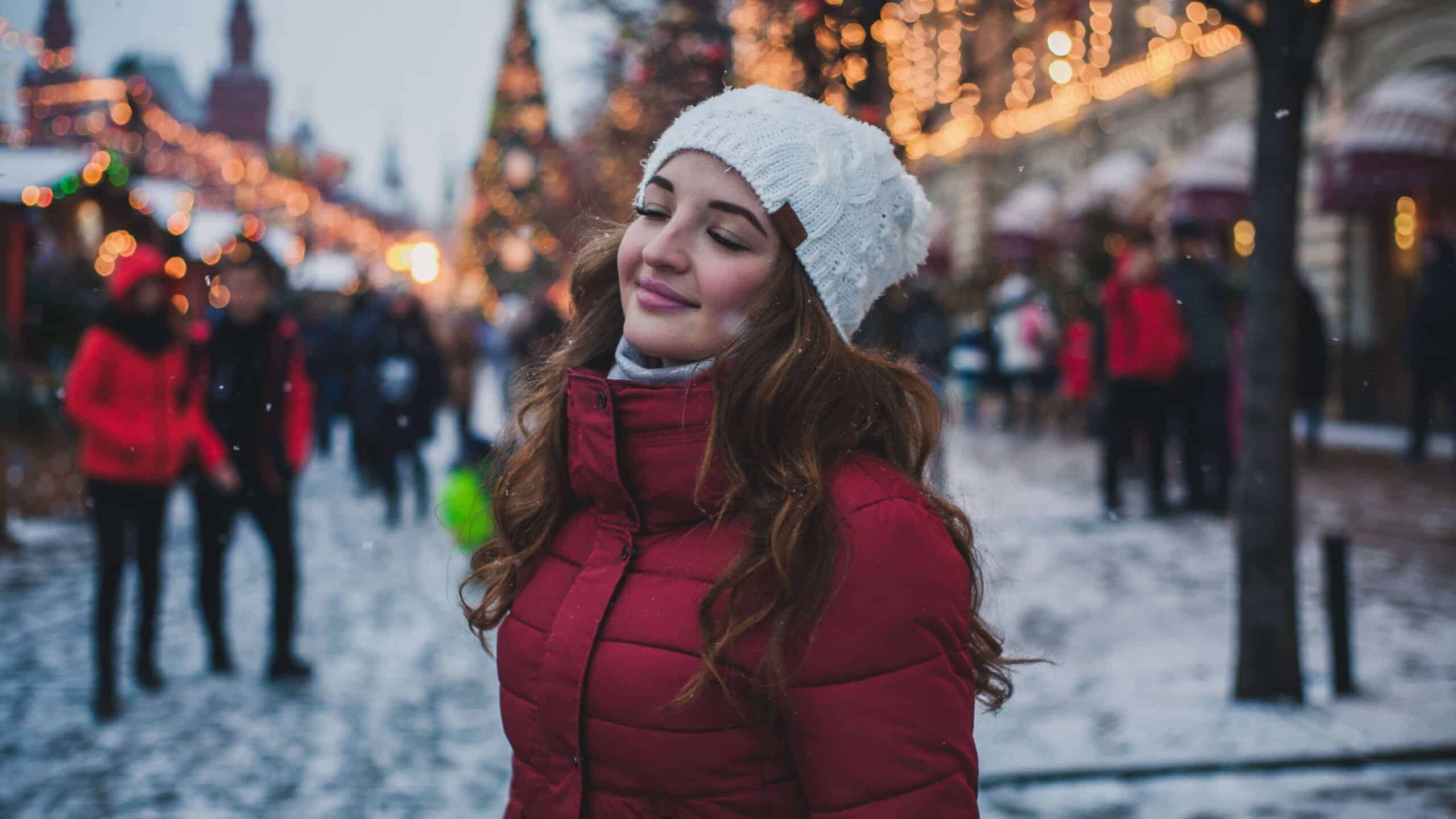 A woman in an outdoor market during the winter time.