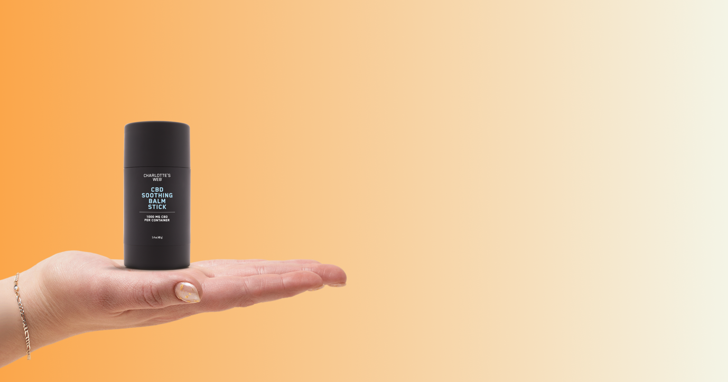 Palm holding CBD Soothing Balm Stick on orange gradient background