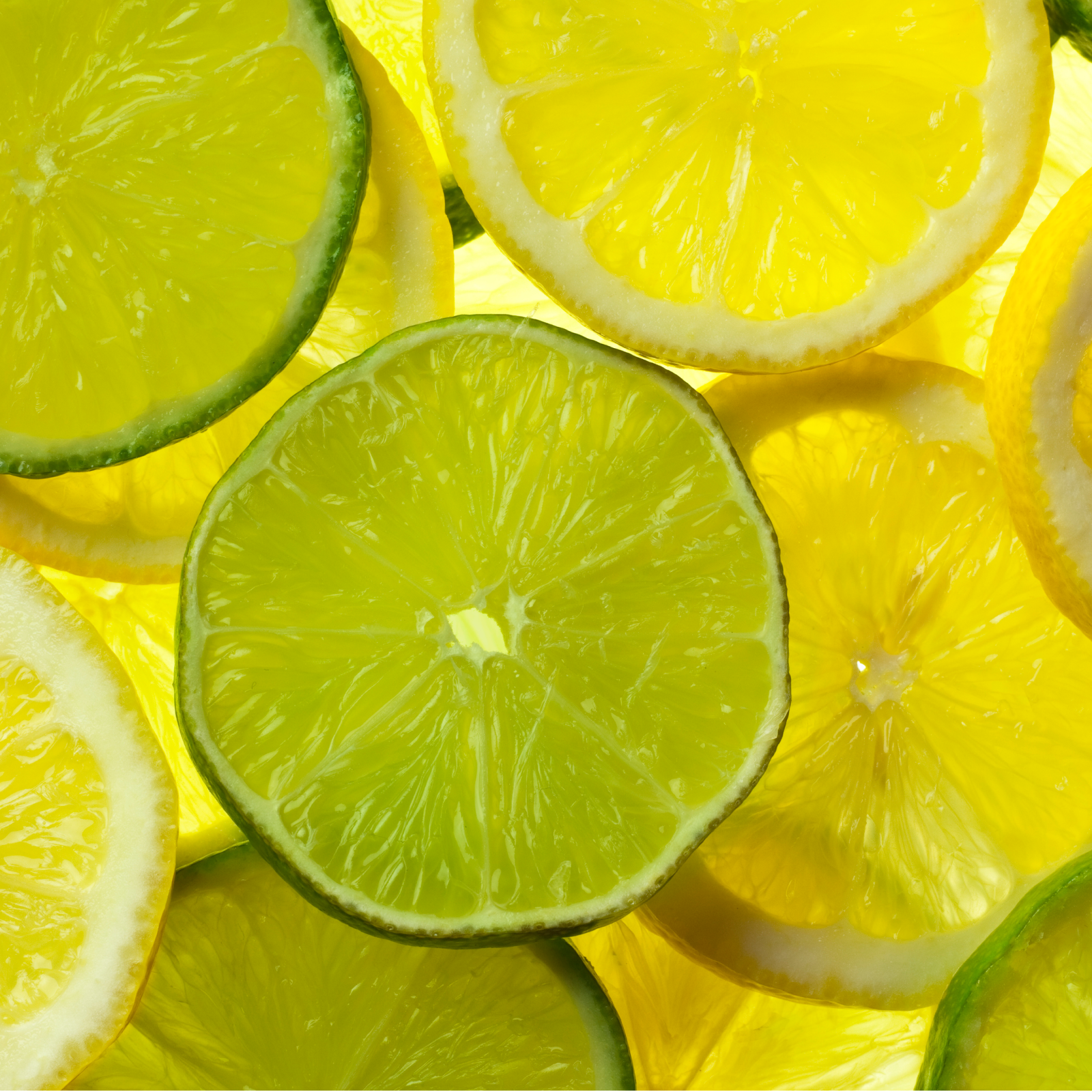 Product Image for Sliced green limes and yellow lemons on a yellow background