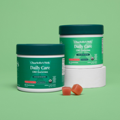 Product Image for Two jars of Charlotte's Web Daily Care CBD Gummies on green background