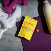 Product Image for Yellow Brightside Recover packet on a purple mat with pink dumbbells and a towel in the background.