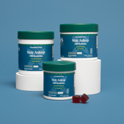 Product Image for Three containers of Charlotte's Web Stay Asleep CBN Gummies on a blue background