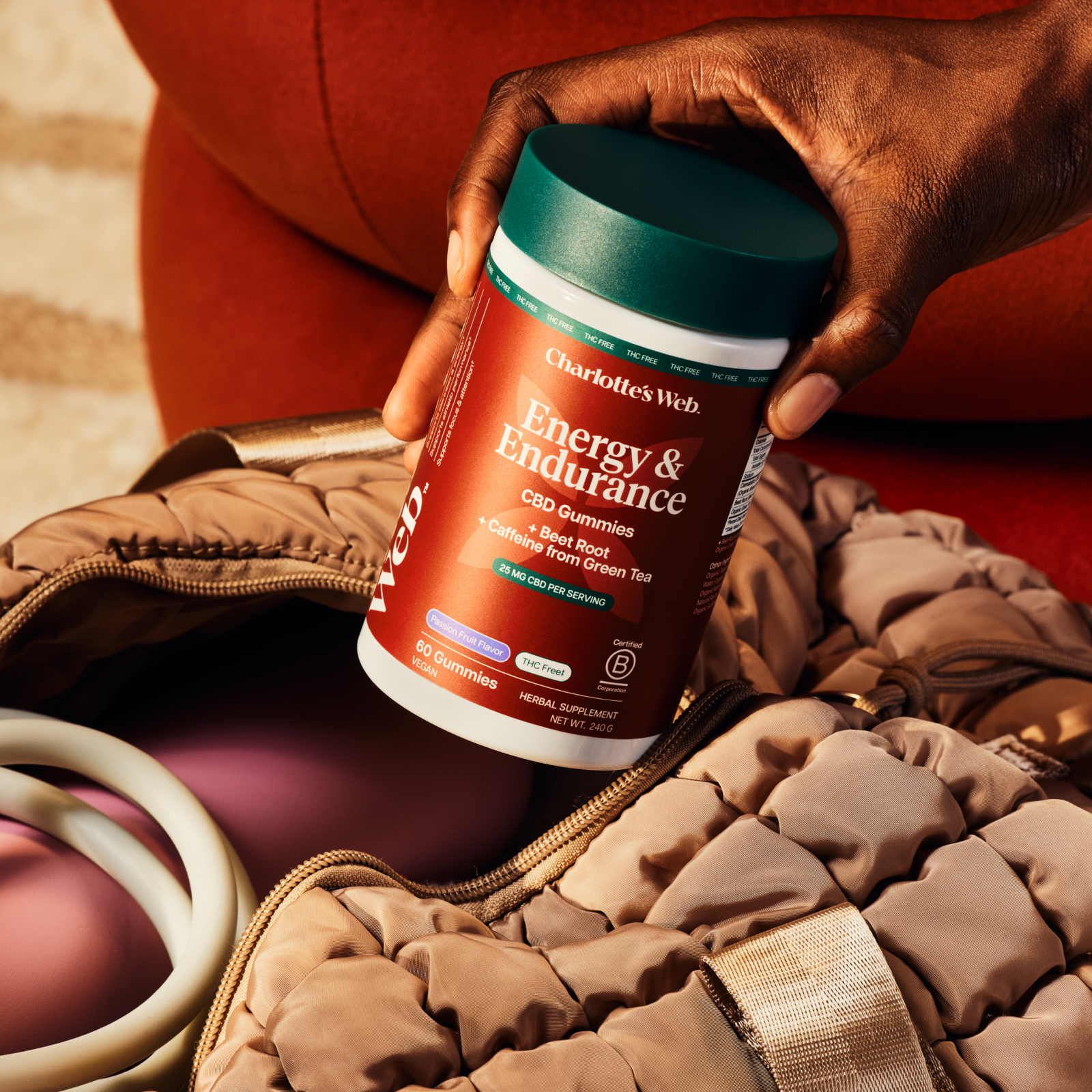 Product Image for Hand holding Energy &amp; Endurance gummies near a gym bag