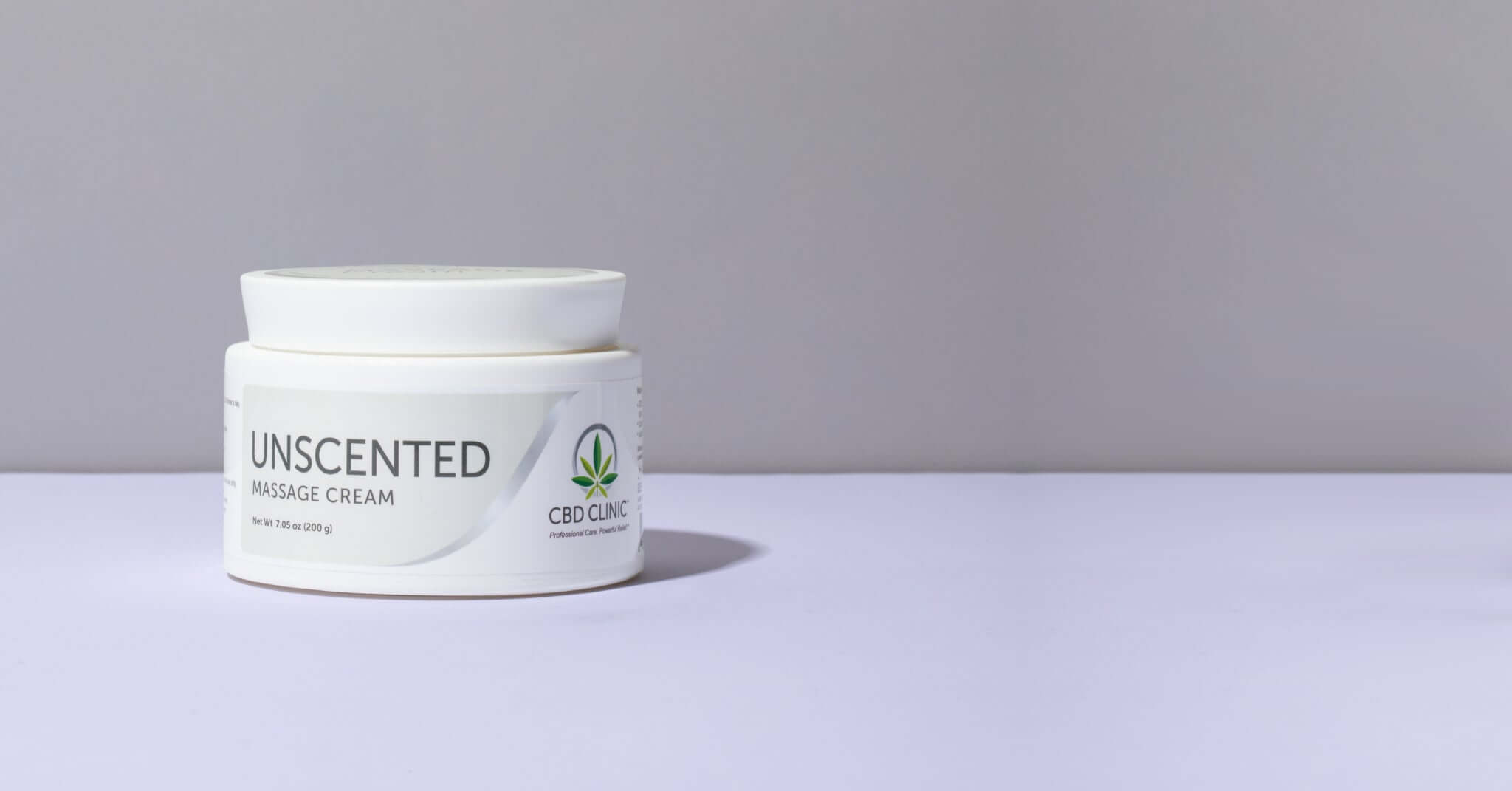 Jar of unscented massage cream on a gray background