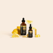 Product Image for Two bottles of Charlotte&#39;s Web lemon thc product with lemon slices on a beige background